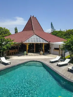 a swimming pool in front of a house at Villa Burung in Kashantee Village in Seminyak