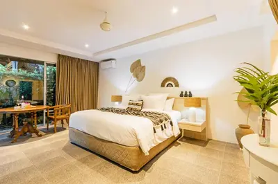 a bedroom with a large bed and a table at Baliani Beauty in Seminyak