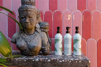 a statue and four bottles of wine on a table at Baliani Beauty in Seminyak