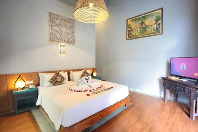 a bedroom with a bed and a television in it at The Reward Villas in Seminyak