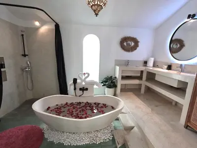 a bathroom with a bath tub and a sink at Villa Curves Bali in Seminyak