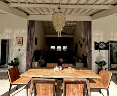 a dining room with a wooden table and chairs at Villa Curves Bali in Seminyak