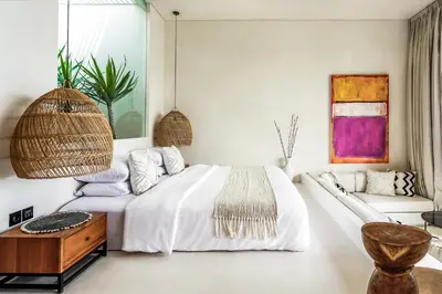 a bedroom with a white bed and a couch at Casa Umalas Villa by Betterplace in Canggu
