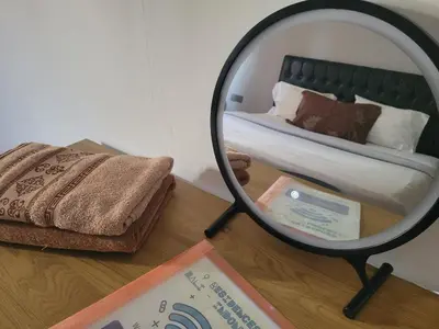 a mirror on a table with a bed in a room at 9 Residence's Seminyak in Seminyak
