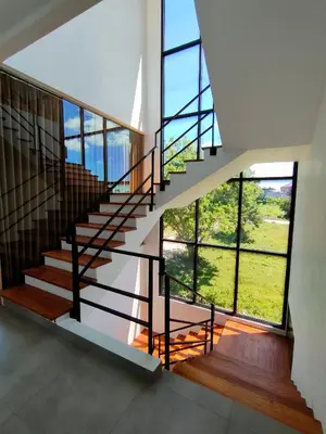 a staircase in a house with large windows at Milo Modern Five-Bedrooms Villa in Jimbaran