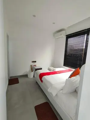 a white bedroom with a bed and a window at Milo Modern Five-Bedrooms Villa in Jimbaran