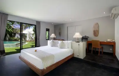a bedroom with a large white bed and a desk at Villa Papaya by Optimum Bali Villas in Canggu