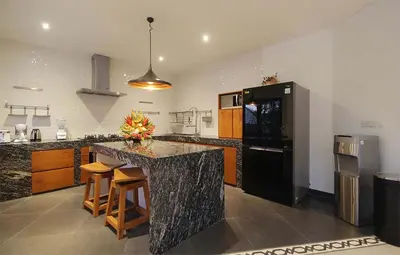 a kitchen with a black refrigerator and a counter at Villa Papaya by Optimum Bali Villas in Canggu
