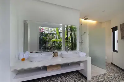 a bathroom with two sinks and a large mirror at Villa Papaya by Optimum Bali Villas in Canggu