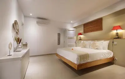 a bedroom with a large white bed in a room at Villa Papaya by Optimum Bali Villas in Canggu