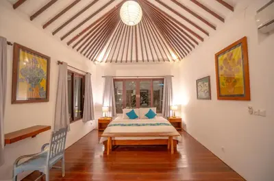 a bedroom with a bed and a chair in a room at Villa Jado 2 - 3 Bedroom Villa With Private Pool in Kerobokan